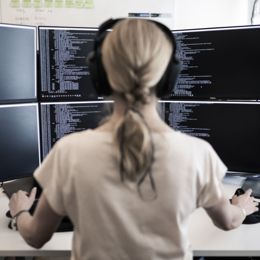 Sakerhetsbolagets-SRS-it-specialist-sitter-framfar-stor-datorskarm-och-arbetar-med-cybersakerhet